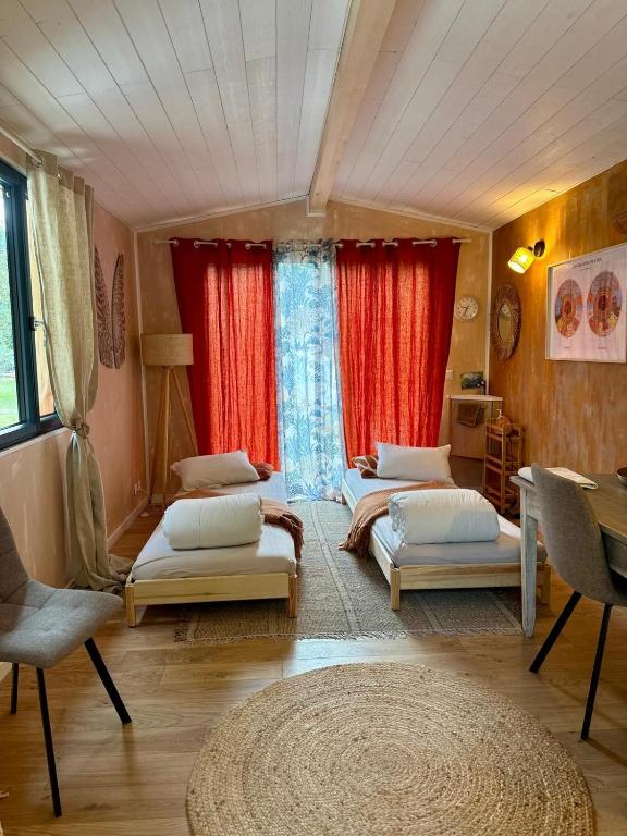 a room with three beds and a window with red curtains at Le Pavillon Vert - B&B in Vedène
