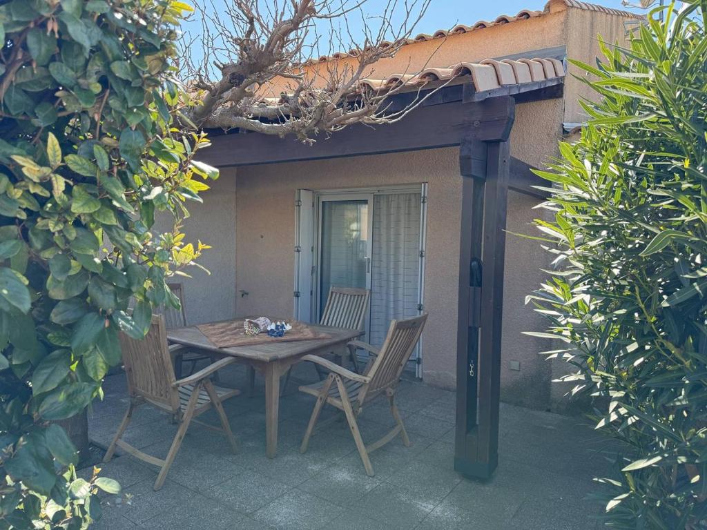 eine Terrasse mit einem Tisch und Stühlen auf einer Terrasse in der Unterkunft HOLIDAYLAND VILLA 217 T2 6 couchages NARBONNE PLAGE in Narbonne-Plage