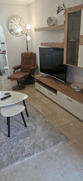 a living room with a flat screen tv and a coffee table at Vistabella golf villa jade in Orihuela Costa