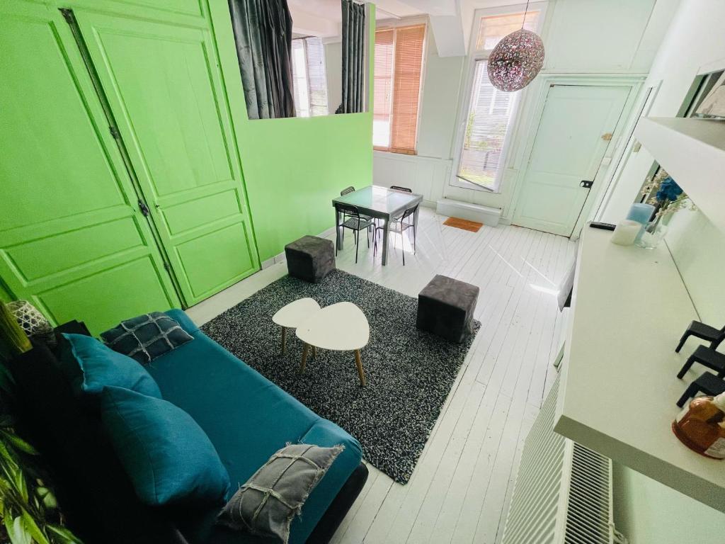 un salon avec un canapé bleu et une table dans l'établissement Appartement Éclatant, Place de la Pucelle - 378, à Rouen
