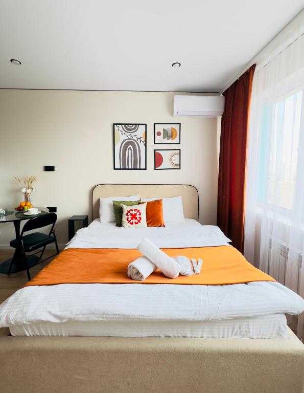 a bedroom with a large bed with towels on it at Студия красивая in Almaty
