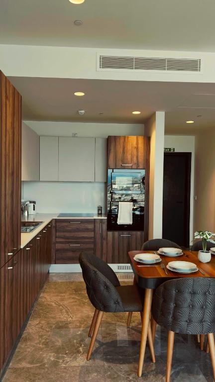 a kitchen with a wooden table and chairs and a counter at Sea view Mercury Tower, Rooftop infinity Pool in St. Julianʼs