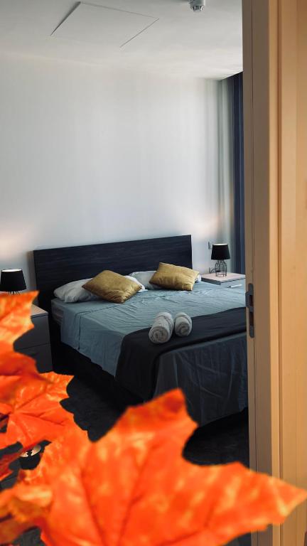 a bedroom with a bed with orange sheets and pillows at Sea view Mercury Tower, Rooftop infinity Pool in St. Julianʼs