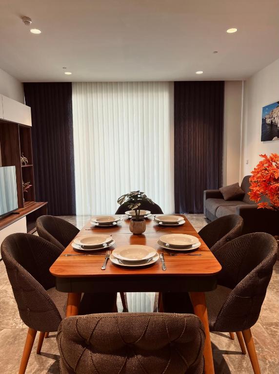 a dining room with a table with chairs and a couch at Sea view Mercury Tower, Rooftop infinity Pool in St. Julianʼs
