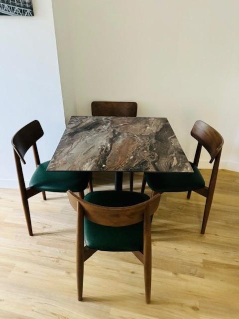 une table en bois avec deux chaises et du parquet. dans l'établissement Appartement Basilique Saint Denys, à Argenteuil