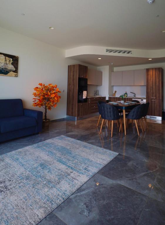 a living room with a blue couch and a table at Sea view Mercury Tower, Rooftop infinity Pool in St. Julianʼs