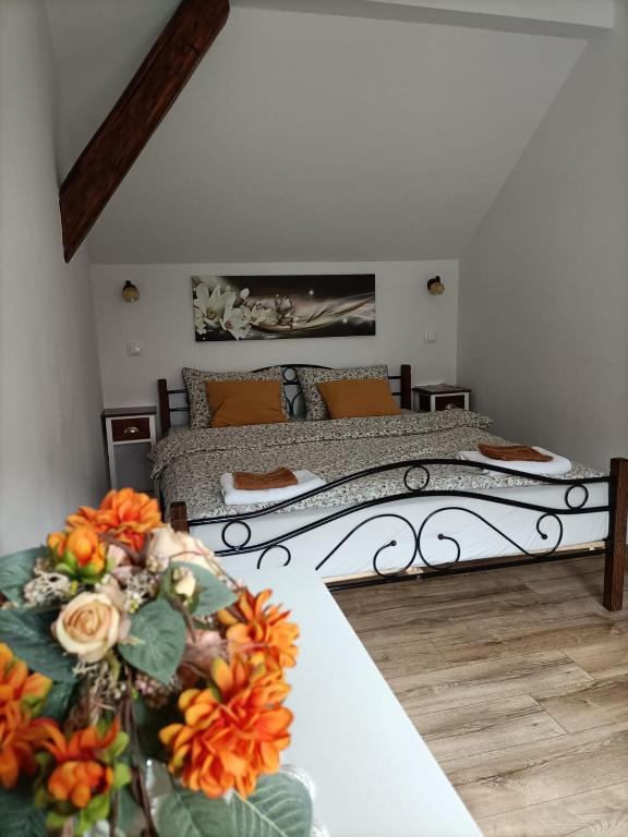 a bedroom with two beds with flowers on the tables at Apartamenty w Stodole in Krościenko