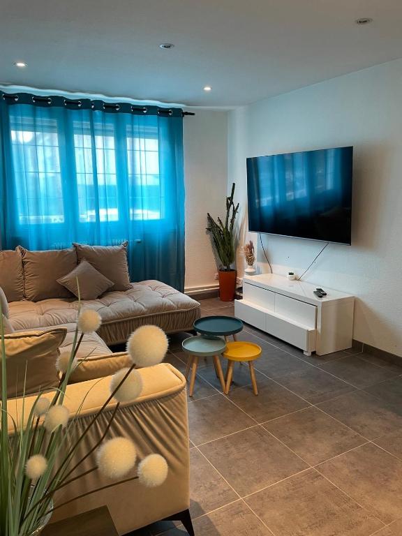 un salon avec un canapé et une télévision à écran plat dans l'établissement Maison proche Nancy Golf, Forêt & Calme à Pulnoy, à Pulnoy