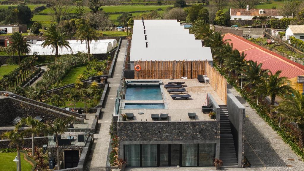 an aerial view of a building with a swimming pool and palm trees at Azores Homes Resort & Spa in Ponta Delgada