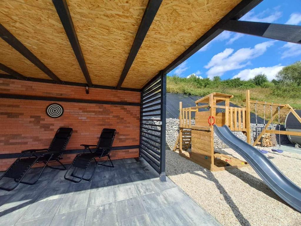 a playground with two chairs and a slide at Chalet Habovka in Habovka