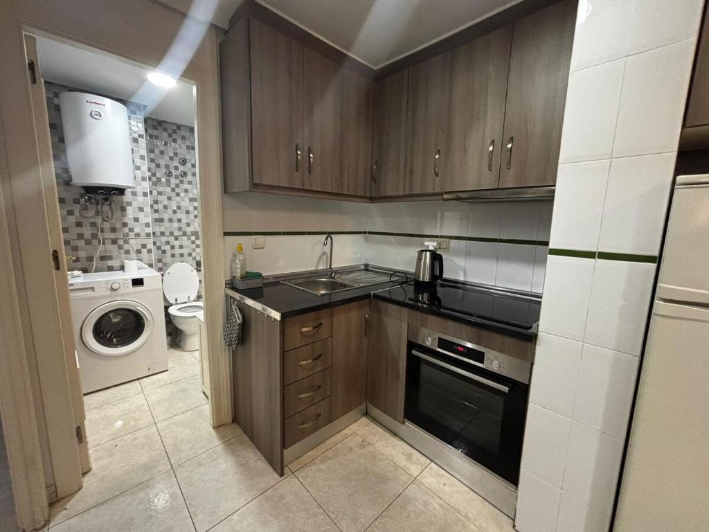 una cocina con fregadero y estufa horno superior en Calle Galeon, en Torrevieja