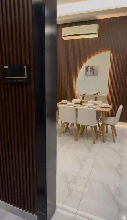 a dining room with a table and white chairs at Hotel Apartment - 1 - LAvner Al hussma in Riyadh