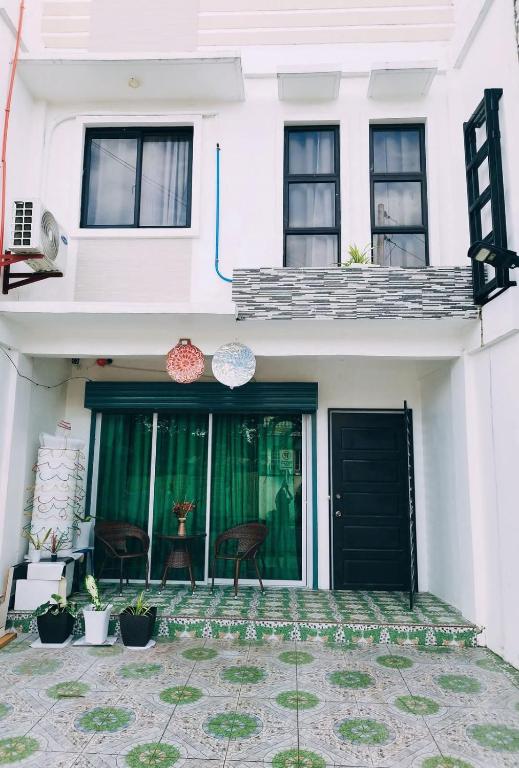 a white house with black doors and a patio at De Richness in Tagbilaran City