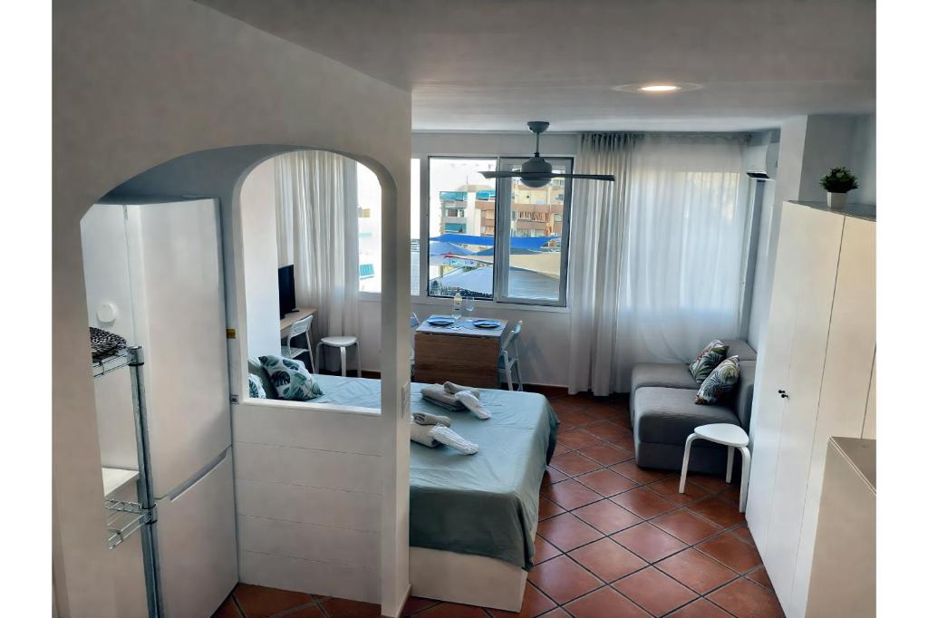 ein kleines Zimmer mit einem Bett und einem Spiegel in der Unterkunft Helios II - Free Parking - By Lcdsol in Torremolinos