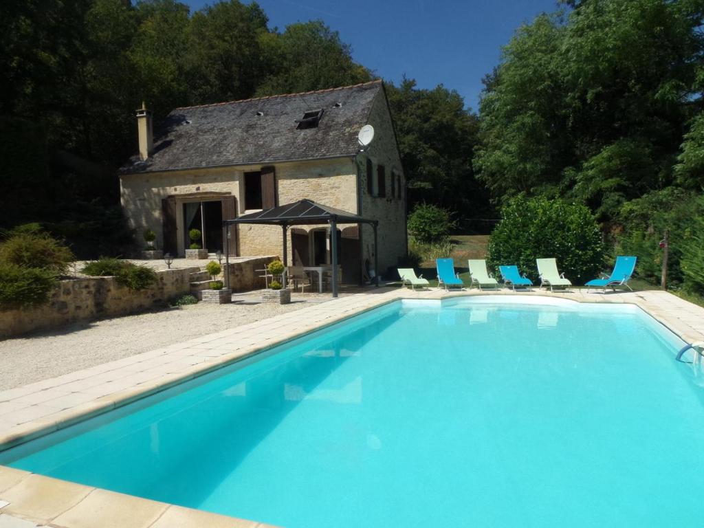une grande piscine devant un immeuble dans l'établissement Canterane, un coin de paradis à la campagne, à Salignac Eyvigues