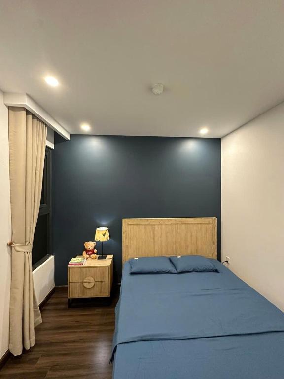 a bedroom with a bed and a blue wall at Homie Homestay in Hai Phong