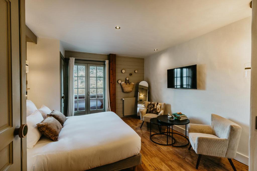 a bedroom with a bed and a table and a chair at Hôtel Restaurant La Ferme de Cupelin in Saint-Gervais-les-Bains