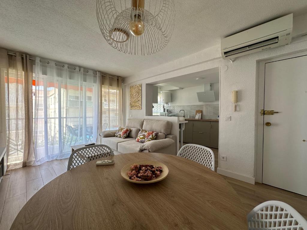 een woonkamer met een tafel en een bank bij SATORI Romantyczny azyl dla dwojga 150 m od plaży - apartament z balkonem i parkingiem, Playa de Gandia in Playa de Gandia