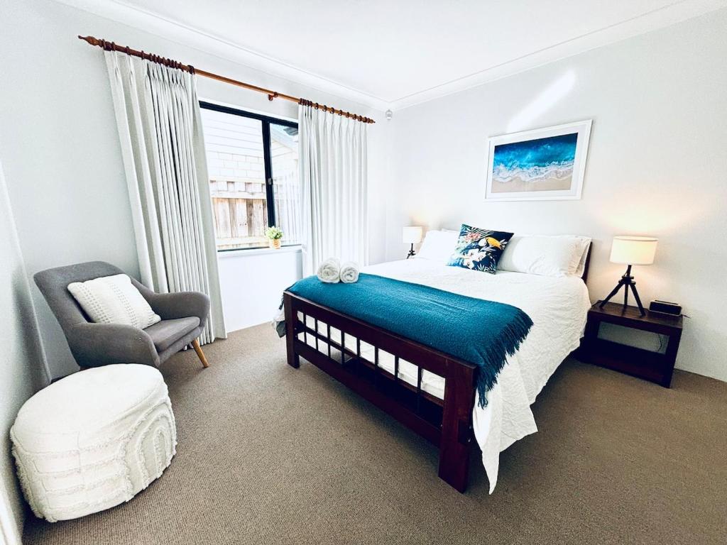 a bedroom with a bed and a chair and a window at Troon Retreat! Golf, Wineries, beaches in Dunsborough