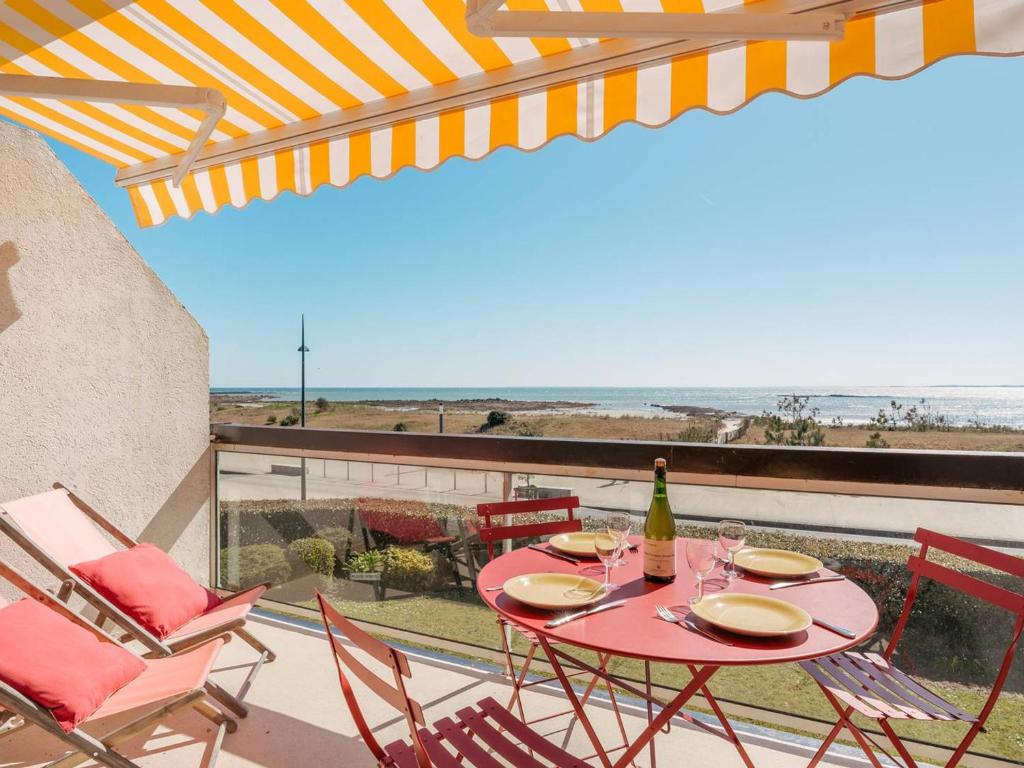 - une table avec une bouteille de vin et des chaises sur le balcon dans l'établissement Carnac - Studio Cabine - 4 Pers - Terrasse - Parking Inclus - FR-1-477-82, à Carnac
