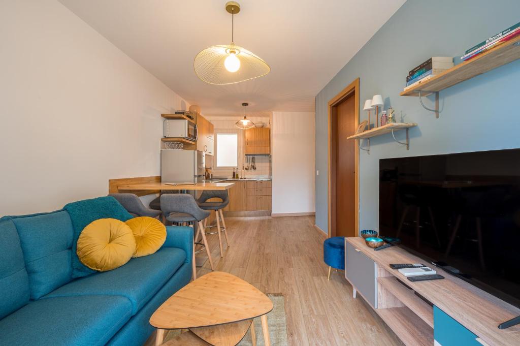 un salon avec un canapé bleu et une cuisine dans l'établissement Magnifique 2 pièces, Clim, parking , wifi, à Beaulieu-sur-Mer