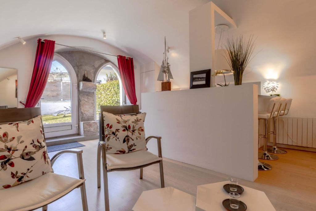 un salon avec deux chaises et une table dans l'établissement Eclat 3 etoiles Parking Gratuit-Proche lac et golf-Au calme, à Talloires