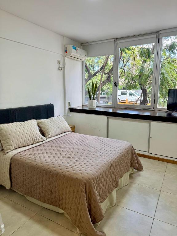 a bedroom with a bed and a large window at Departamento Independencia in Buenos Aires