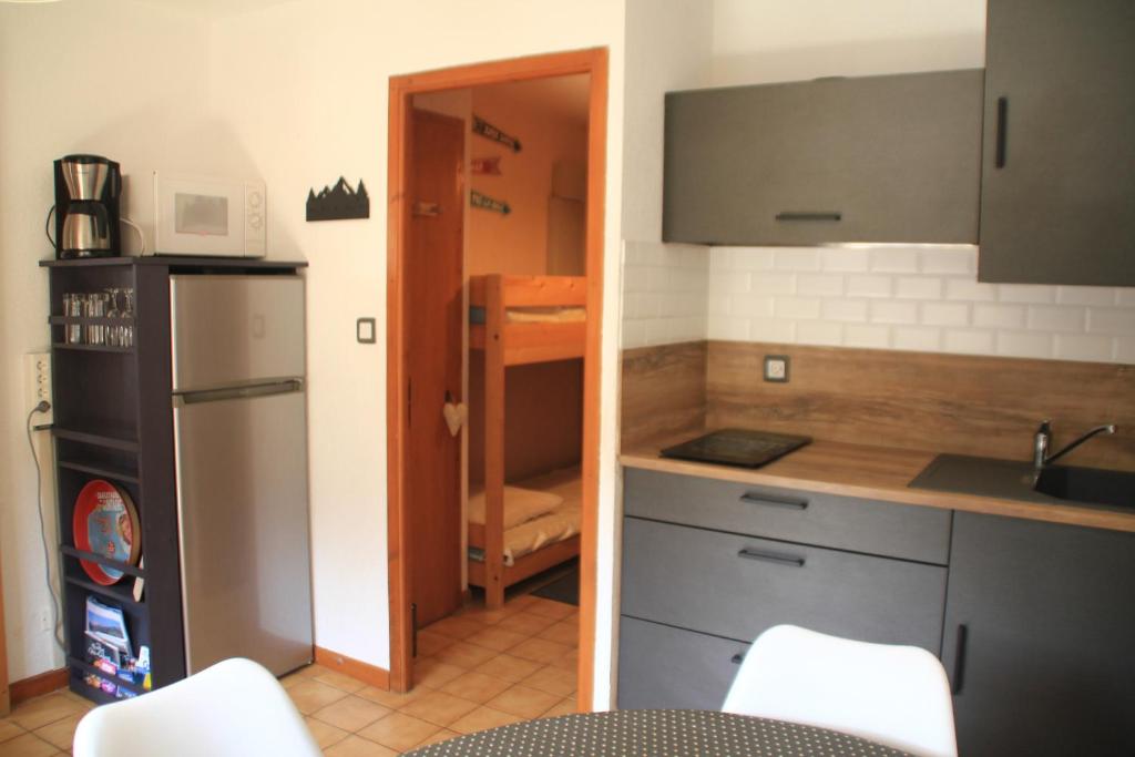 une cuisine avec un évier et un réfrigérateur dans l'établissement VOINETTES VNB8 TELECABINE & MOUNTAIN 4 Pers, à Châtel