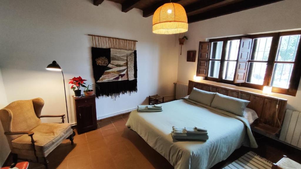 una camera con letto, sedia e lampada di BLISS HOME Lagunas de Villafáfila a Villalba de la Lampreana