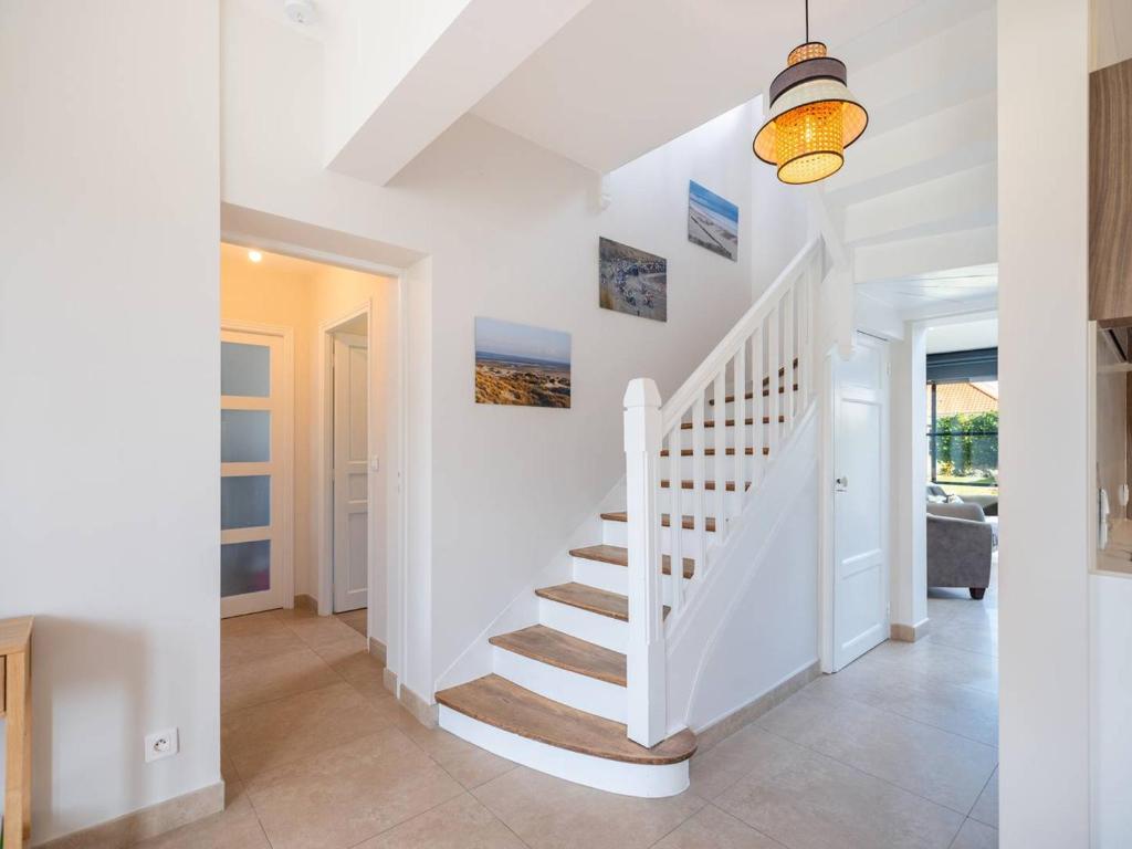 - un escalier dans une maison dotée de murs blancs et d'un plafond dans l'établissement Maison spacieuse avec Wi-Fi et parking, proche plage - FR-1-821-16, à Le Touquet-Paris-Plage