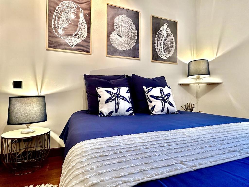 - une chambre dotée d'un lit bleu avec des photos sur le mur dans l'établissement Cap sur l'Océan à 50m plages et piscine naturelle, à Saint-Gilles-Croix-de-Vie