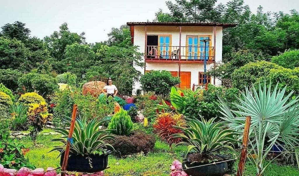 un uomo seduto in un giardino davanti a una casa di Centro recreacional y turístico Villa Leones a La Jagua de Ibirico