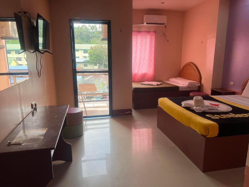 a small room with two beds and a window at Rielena Plaza Hotel and Suites in Molave