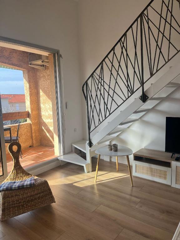 un salon avec un escalier et une table dans l'établissement Bulle Marine, à Bandol