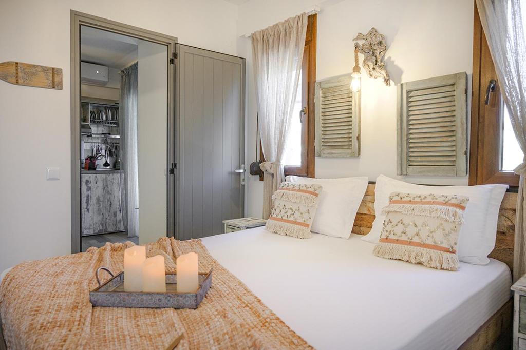 ein Schlafzimmer mit einem großen Bett mit zwei Kerzen darauf in der Unterkunft Meltemi luxury apartments in Nea Roda