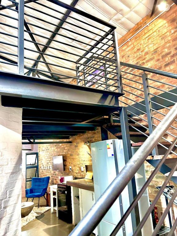 a staircase in a room with a blue chair at Craftsmenship Loft in Johannesburg