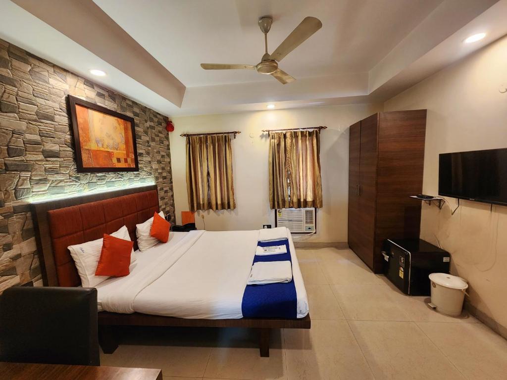a bedroom with a bed and a flat screen tv at Bhammar's Inn - A Pure Veg in Kolkata