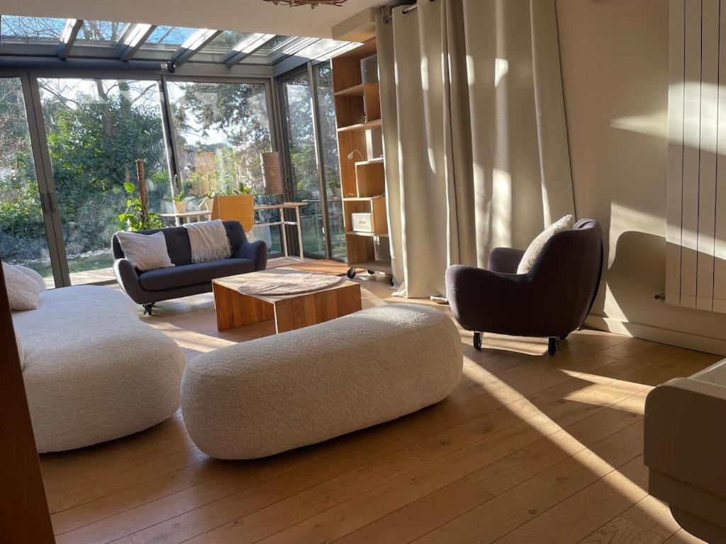 Elle comprend un salon meublé et une grande fenêtre. dans l'établissement Glass and wood designer villa with garden in centertown, à Montpellier