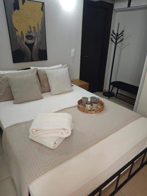 a bed with a tray of towels on it at Mary's Cozy apartment in Alexandroupoli