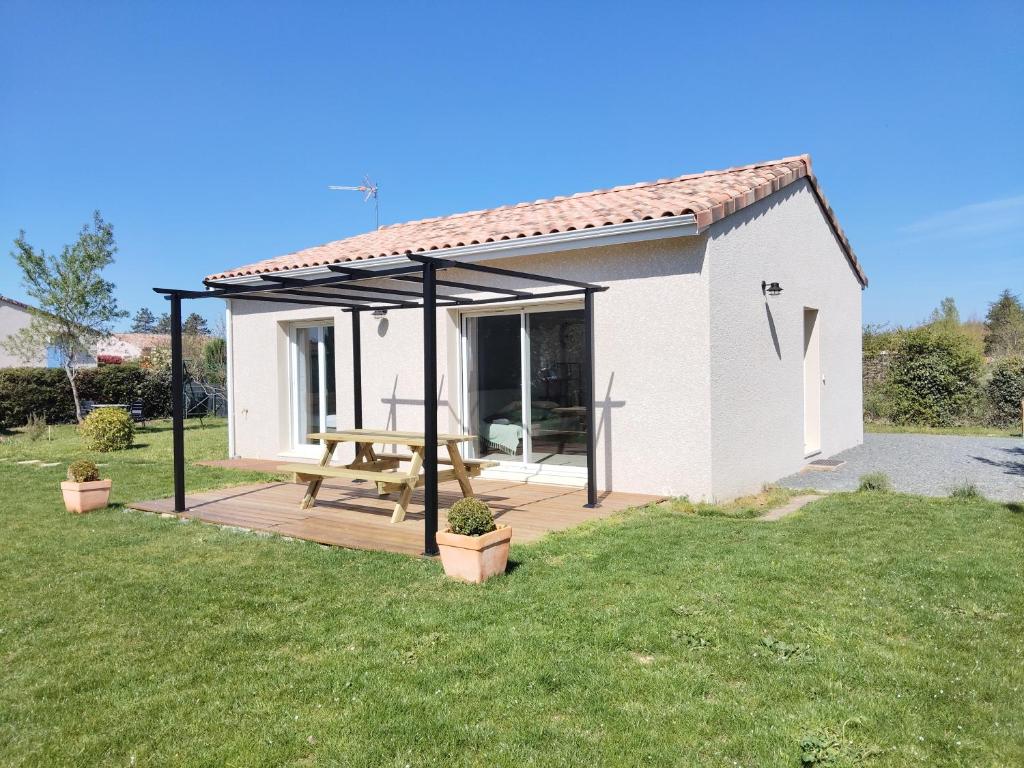 une petite maison blanche avec une table de pique-nique sur une terrasse dans l'établissement Gîte Le Pastel Du Midi, à Gaillac