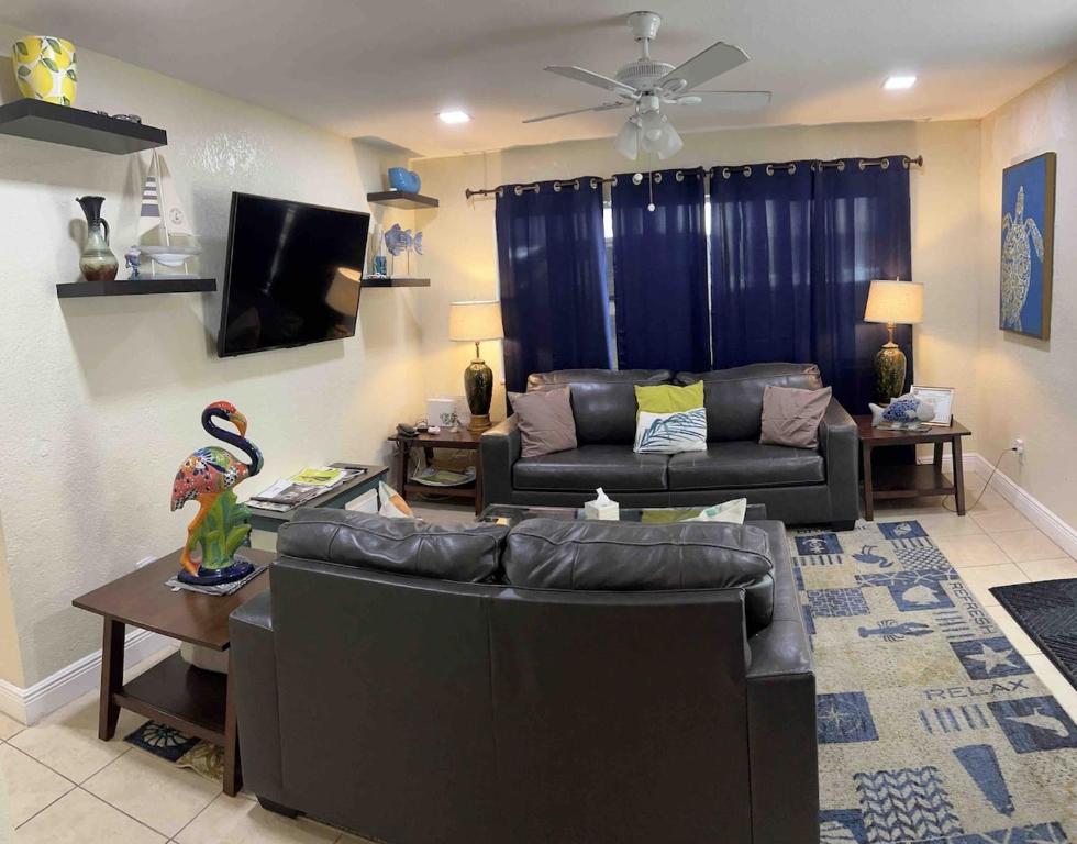 a living room with a couch and a tv at Great 4b2b getaway with heated salt water pool in Fort Lauderdale