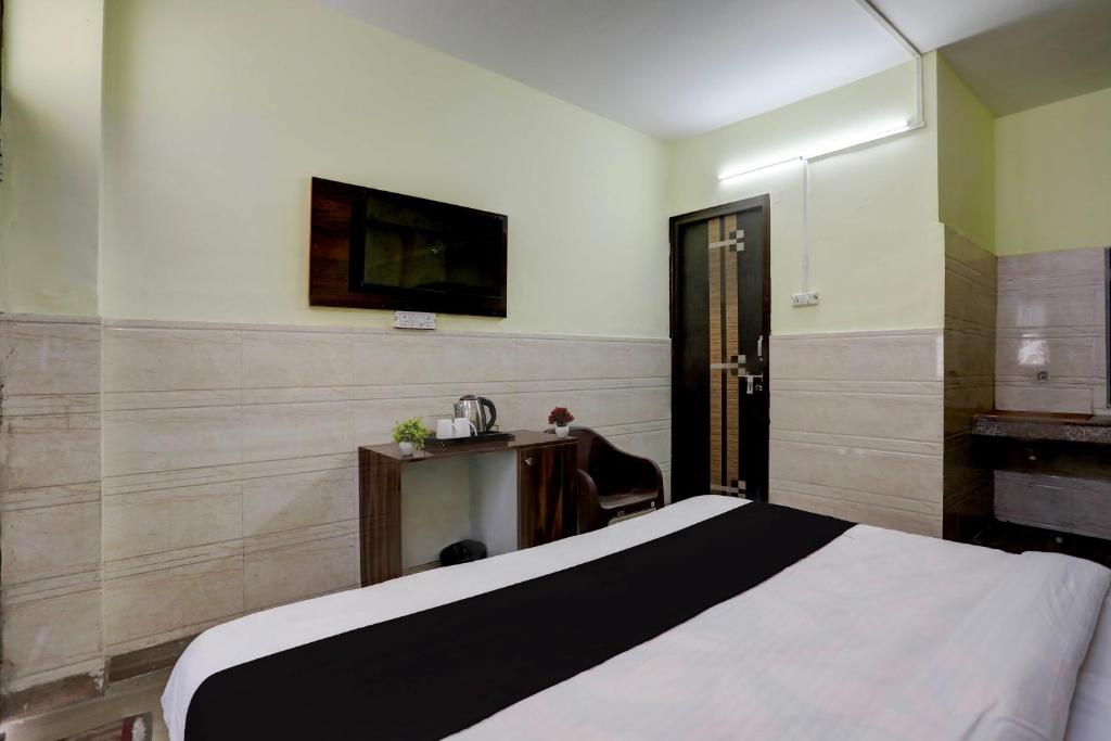 a bedroom with a bed and a tv on the wall at Hotel O vista 18 inn in Noida