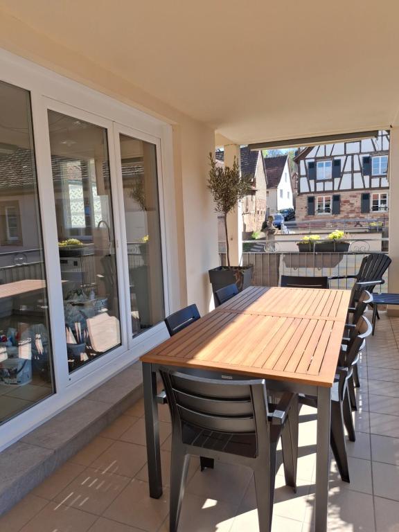 une table et des chaises en bois sur un balcon dans l'établissement Le Repaire des Hirondelles - Le Schopf, à Scharrachbergheim-Irmstett