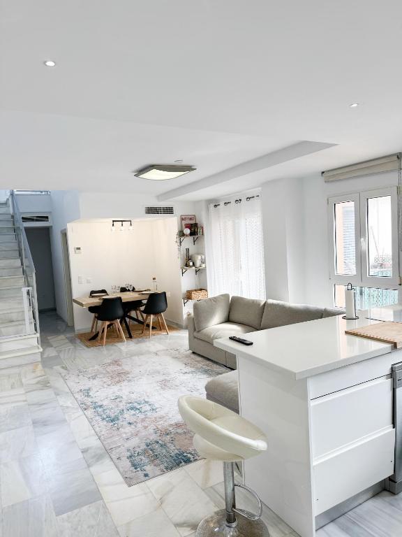 a white living room with a couch and a table at Duplex Penthouse with Seaview. in Benalmádena