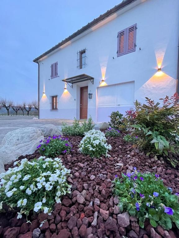 a white house with flowers in front of it at Castrum Gallani in Barberino di Mugello