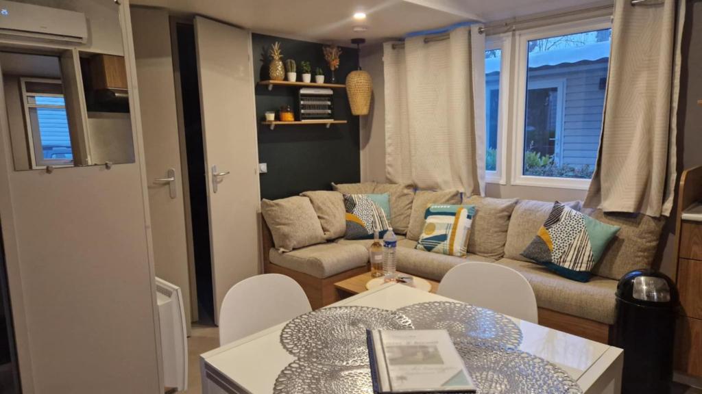 una sala de estar con un sofá y una mesa en Mobihome les sables du midi, en Valras-Plage