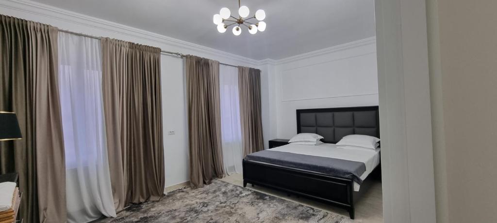 a bedroom with a bed and a chandelier at Studio 1 in Târgu Neamț