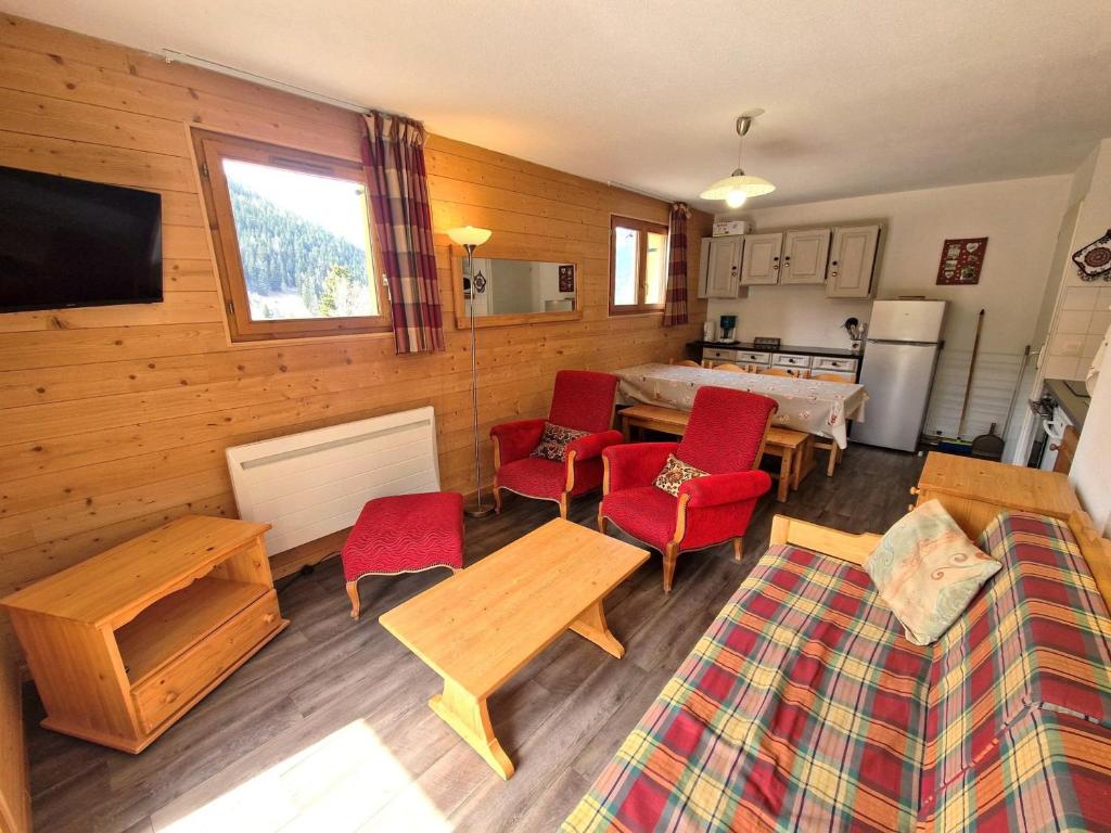 un salon avec des chaises rouges et un canapé dans l'établissement Appartement 4 pièces pour 6/8 personnes avec terrasse, proche pistes et centre à Valfréjus - FR-1-265-172, à Valfréjus