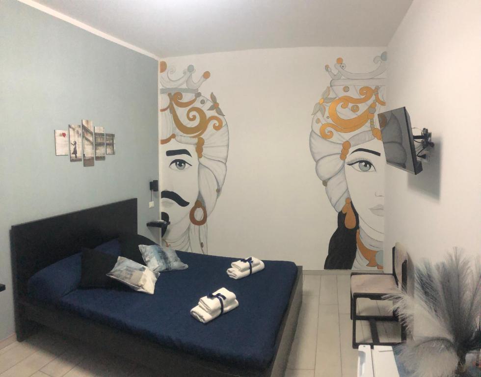 a bedroom with a bed with a mural of two women at Affitti brevi TAORMINA in Realmonte