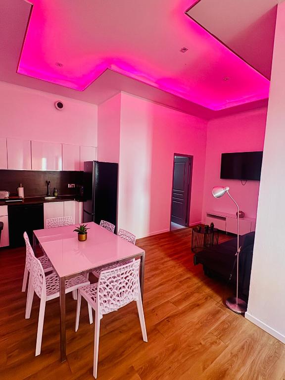 une salle à manger avec une table et un plafond rose dans l'établissement jolie maison individuelle 50 m2 ,design et climatisée, tout confort, wifi, terasse privée , 5 min plage et autoroute, stationnement gratuit, à Marseille